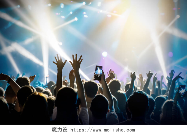 一群人看音乐表演举手表决舞台上的音乐节目，大厅里的人